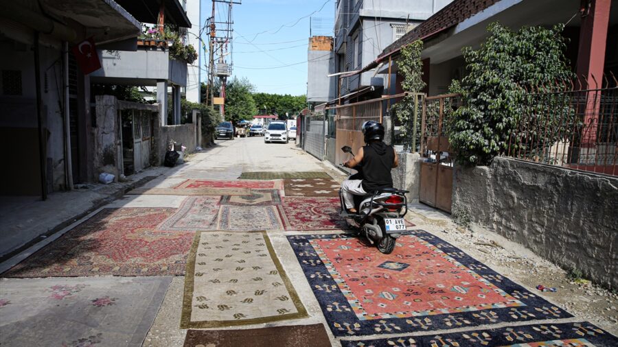 Adana’da mahalle sakinleri asfaltlanmayan yoldaki çukurları halılarla kapattı